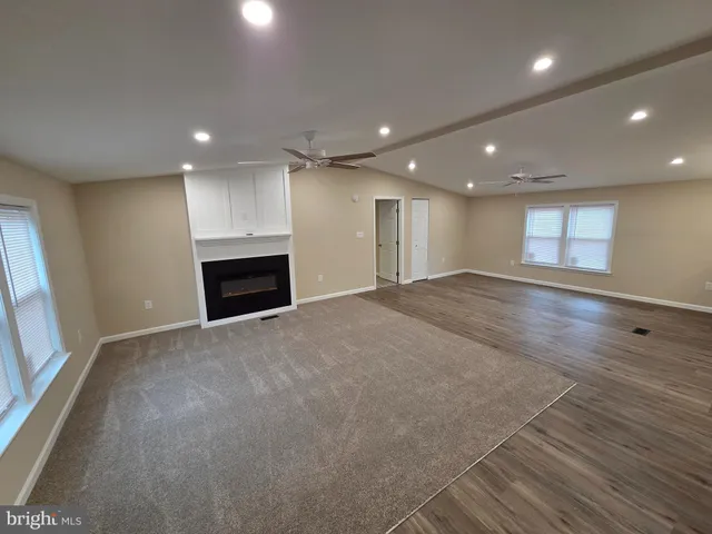 a view of an empty room with a fireplace and a window