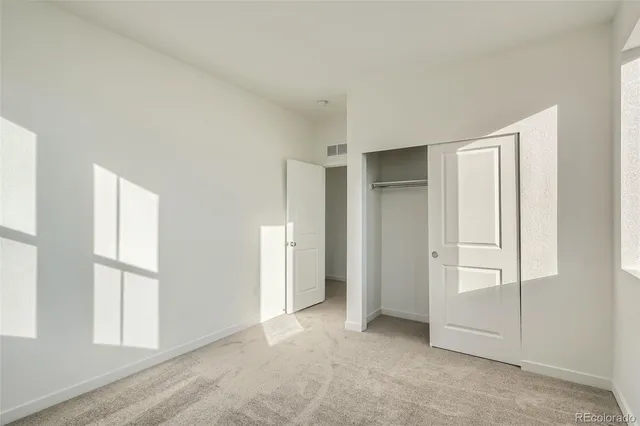 an empty room with windows and closet