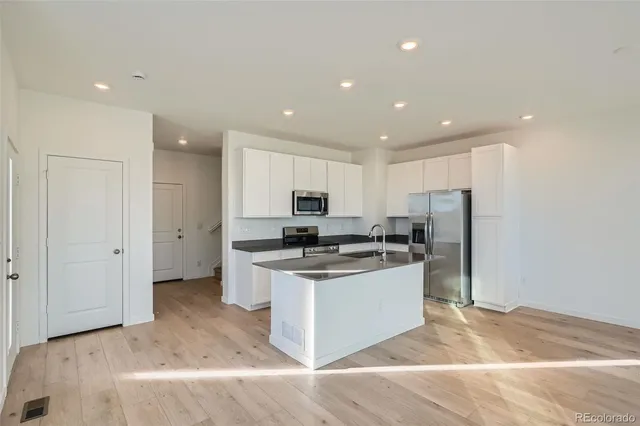 a kitchen with stainless steel appliances kitchen island a sink stove and refrigerator
