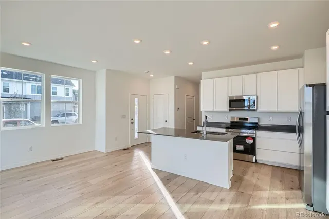 a kitchen with stainless steel appliances kitchen island granite countertop a refrigerator and microwave