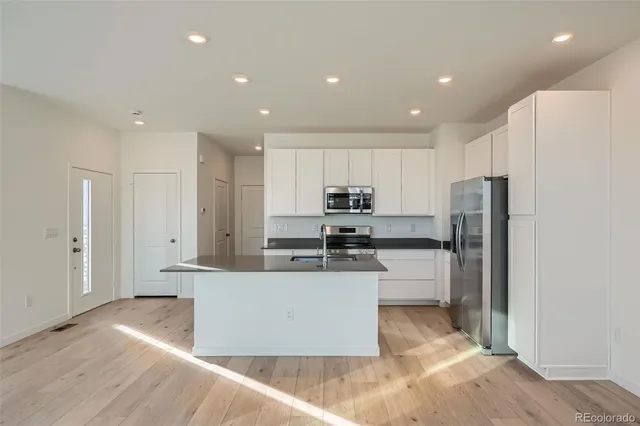 a kitchen with stainless steel appliances a refrigerator and a stove top oven