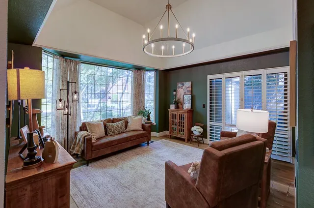 a living room with furniture ceiling fan and a floor to ceiling window