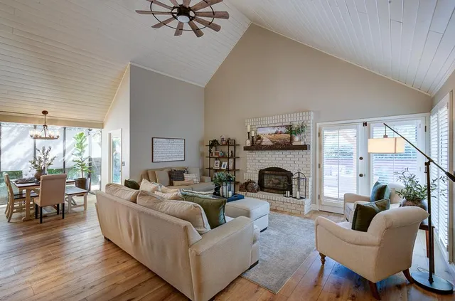 a living room with furniture a fireplace and a floor to ceiling window