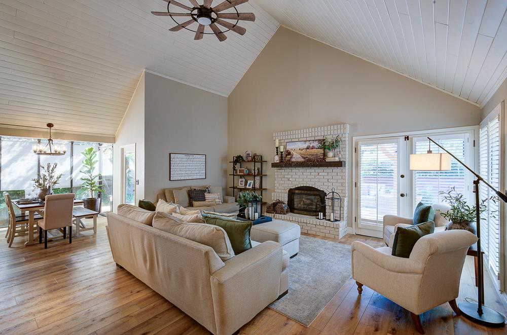 2555 West Bluff Avenue, Unit 152 Fresno, CA 93711 - Photo 2 of 45 a living room with furniture a fireplace and a floor to ceiling window