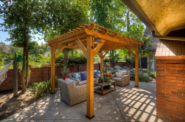 a view of a patio with couches and table and chairs under an umbrella