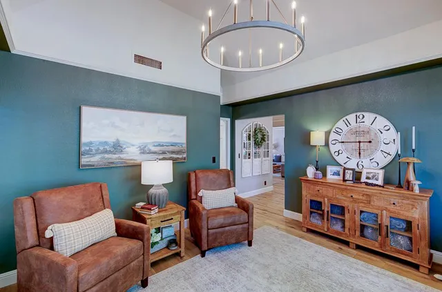 a living room with furniture a baby crib and a chandelier