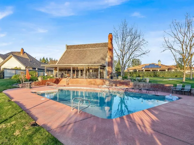 a view of a house with swimming pool and sitting area