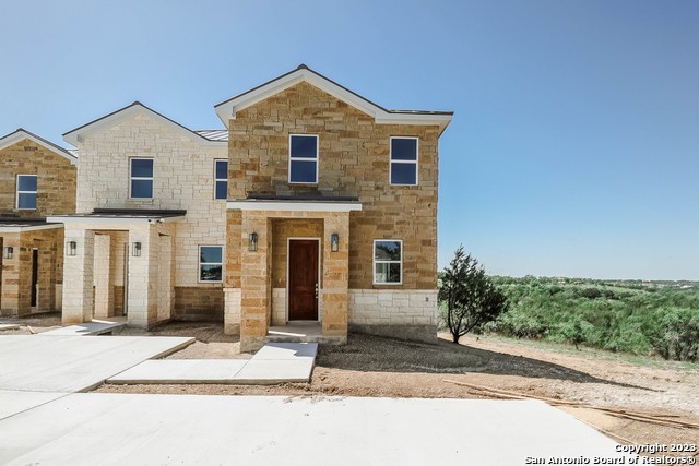 289 Star Grass, Unit B Spring Branch, TX 78070 - Photo 2 of 15 a front view of a house with a yard and garage