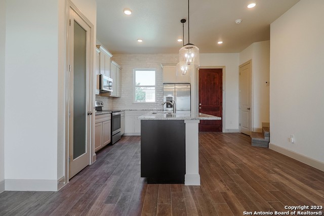 289 Star Grass, Unit B Spring Branch, TX 78070 - Photo 9 of 15 a kitchen with kitchen island wooden floors appliances and cabinets