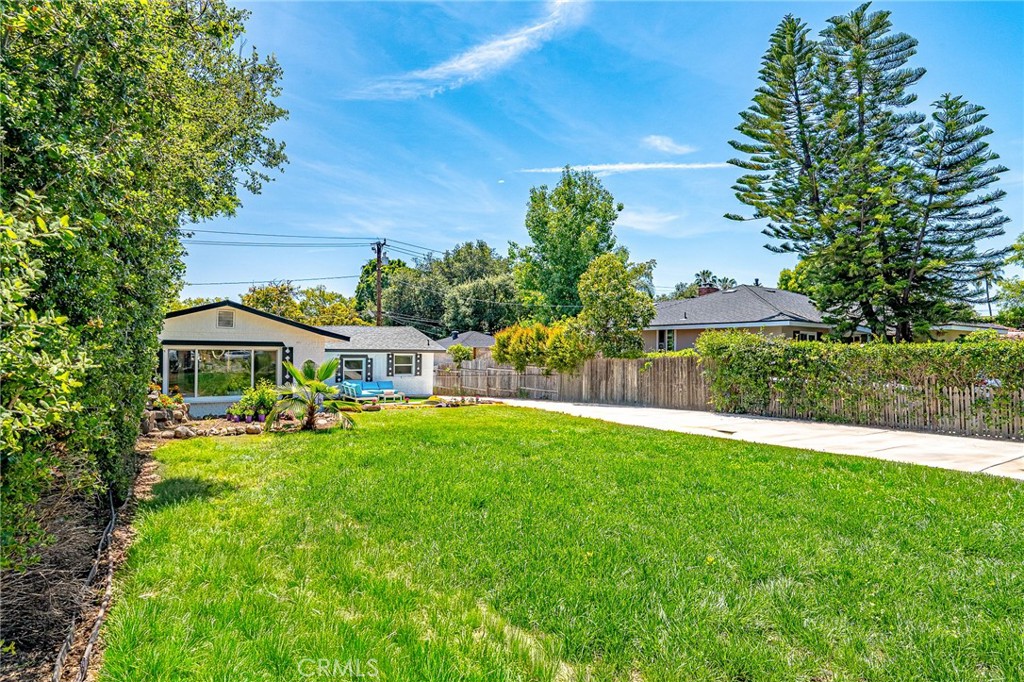 1280 East Woodbury Road Pasadena, CA 91104 - Photo 3 of 40 a front view of a house with a yard table and chairs