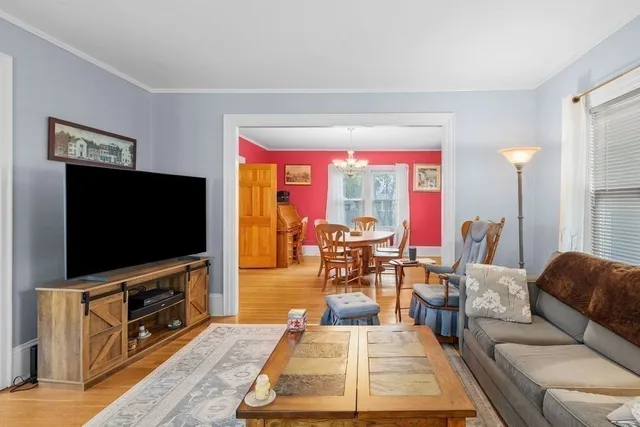a living room with furniture a rug and a floor to ceiling window