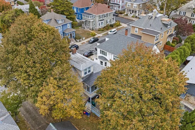 an aerial view of a house with a yard and parking space