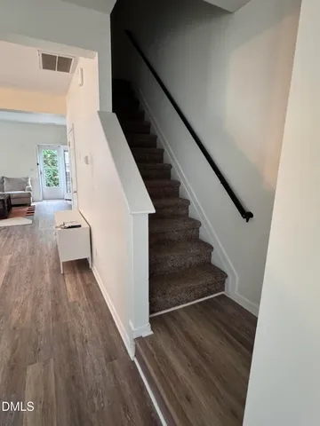 a view of entryway and hall with wooden floor