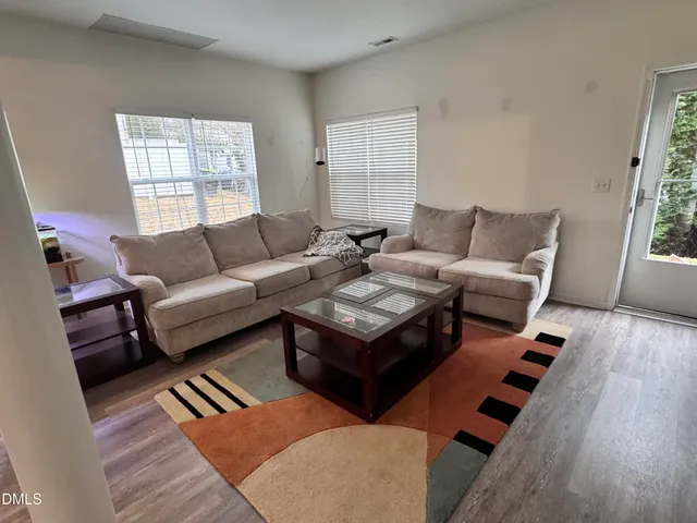 a living room with furniture and wooden floor