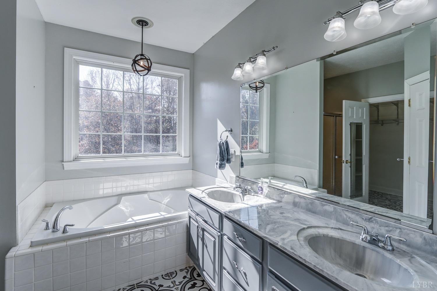 1835 Aspen Road Phenix, VA 23959 - Photo 46 of 84 a bathroom with a granite countertop sink a large mirror and a bathtub
