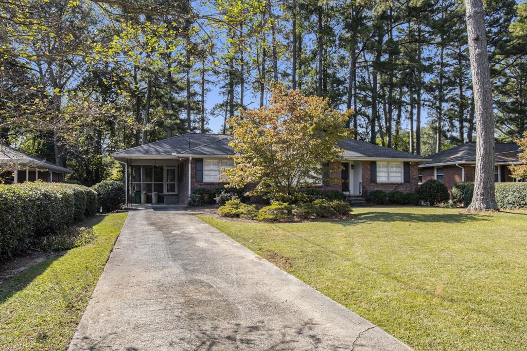 a front view of a house with a yard and trees