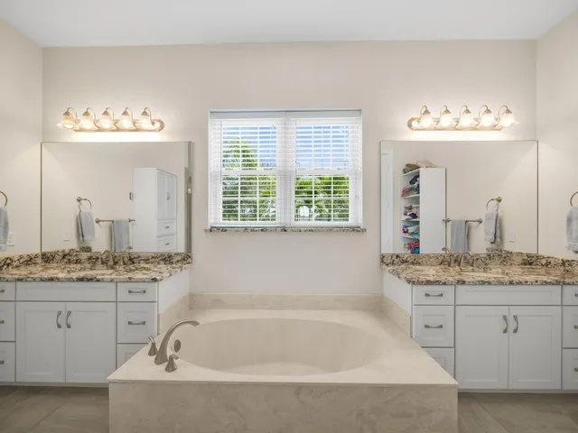 a bathroom with a granite countertop sink mirror and a bathtub