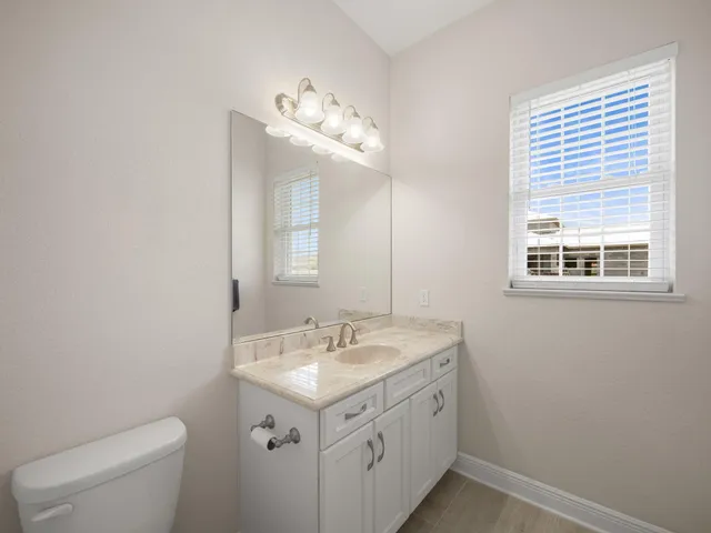 an empty room with windows and ceiling fan