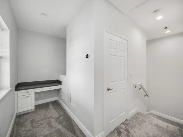 an empty room with a window and a fan