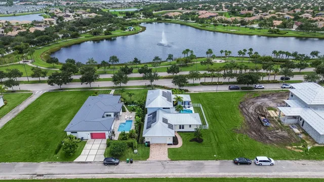 an aerial view of a house with a garden and lake view