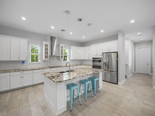 a kitchen with stainless steel appliances granite countertop a stove a sink a refrigerator and a oven