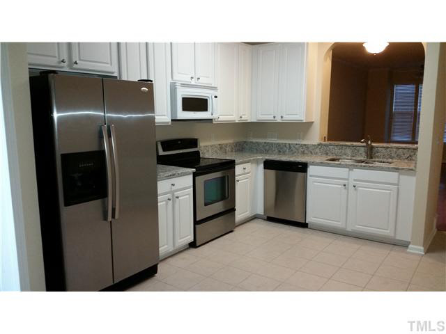 7663 Winners Edge Street Raleigh, NC 27617 - Photo 4 of 16 a kitchen with stainless steel appliances a stove sink and refrigerator