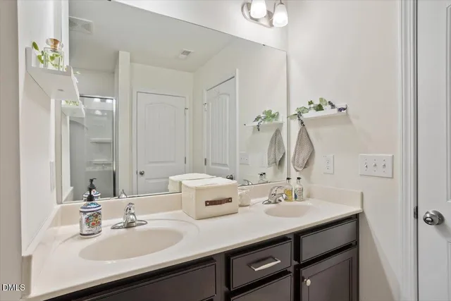 a bathroom with double vanity sinks and a mirror