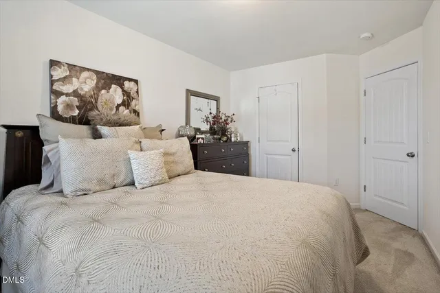 a large bed in a bedroom with a painting on the wall