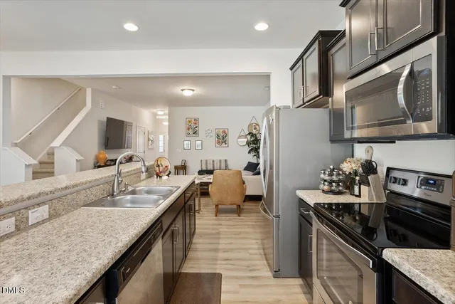 a kitchen with stainless steel appliances granite countertop a sink stove and refrigerator