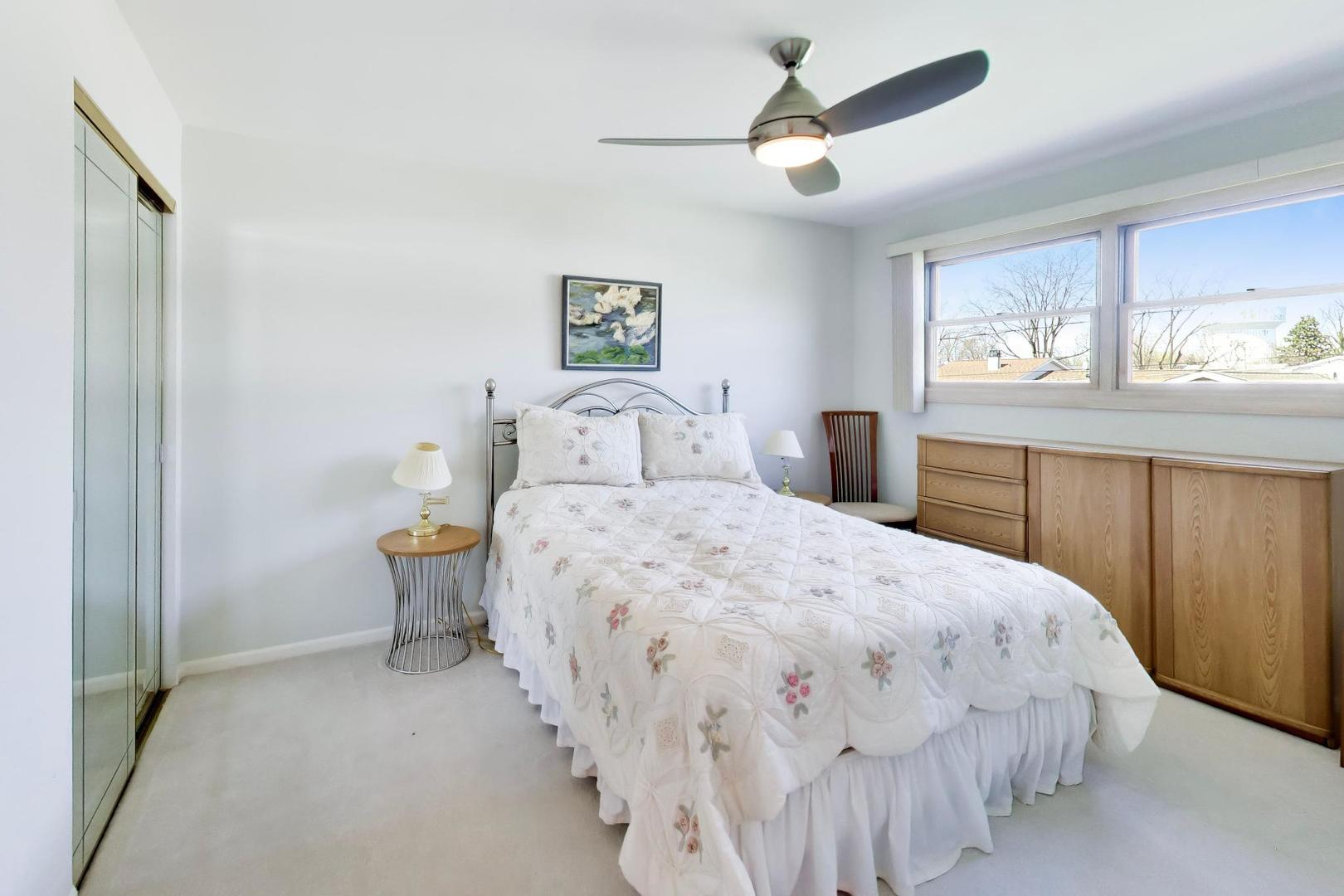634 West Millers Road Des Plaines, IL 60016 - Photo 15 of 42 a bedroom with a large bed and a chandelier