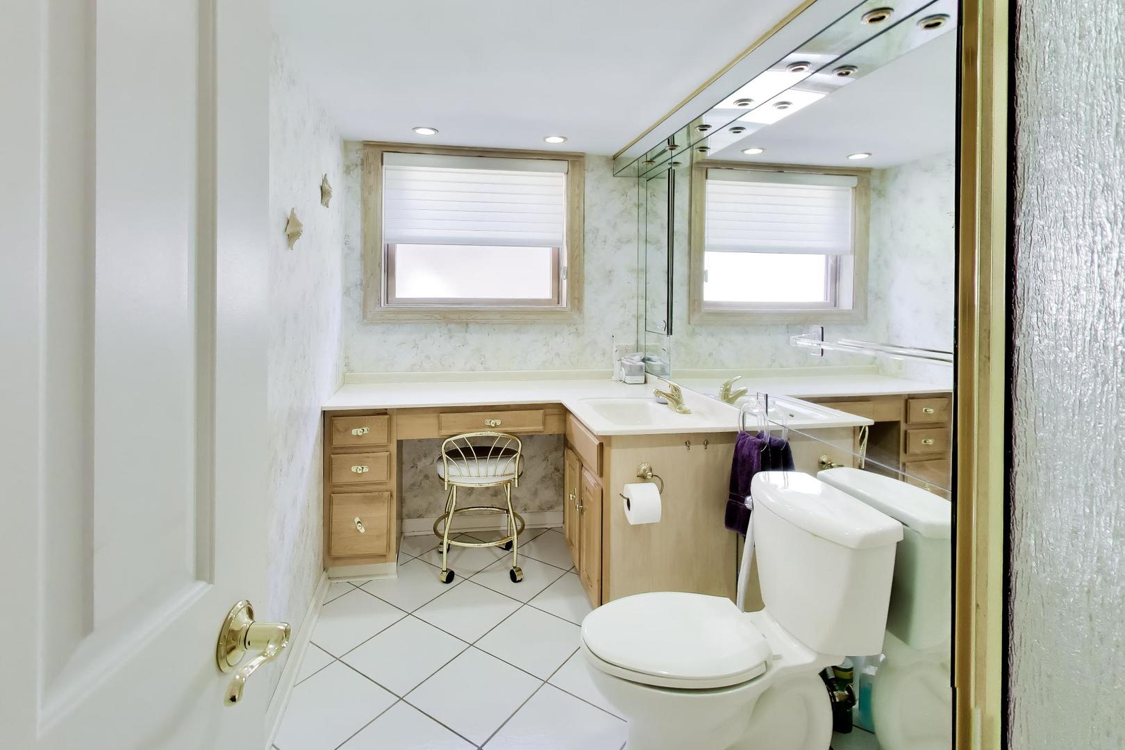634 West Millers Road Des Plaines, IL 60016 - Photo 27 of 42 a bathroom with a granite countertop toilet sink and mirror