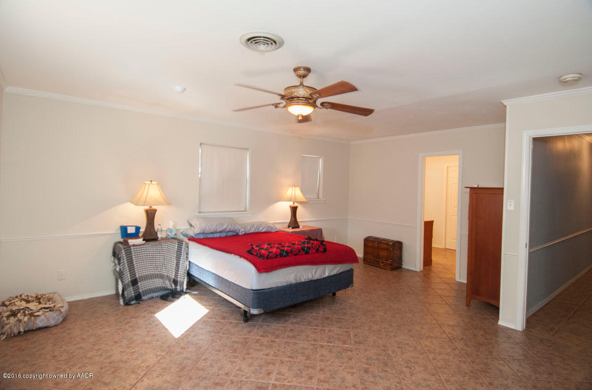 7203 Dreyfuss Road Amarillo, TX 79106 - Photo 14 of 22 a bedroom with a bed and a chandelier