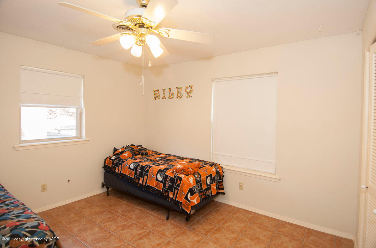 7203 Dreyfuss Road Amarillo, TX 79106 - Photo 17 of 22 a bedroom with a bed and a chandelier