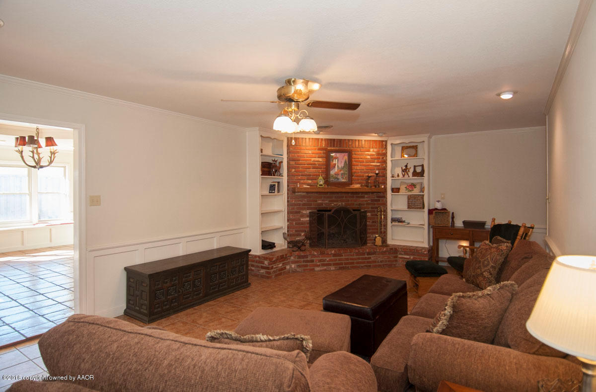 7203 Dreyfuss Road Amarillo, TX 79106 - Photo 5 of 22 a living room with furniture a fireplace and a flat screen tv