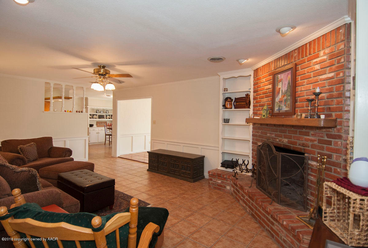 7203 Dreyfuss Road Amarillo, TX 79106 - Photo 6 of 22 a living room with furniture a fireplace and a flat screen tv