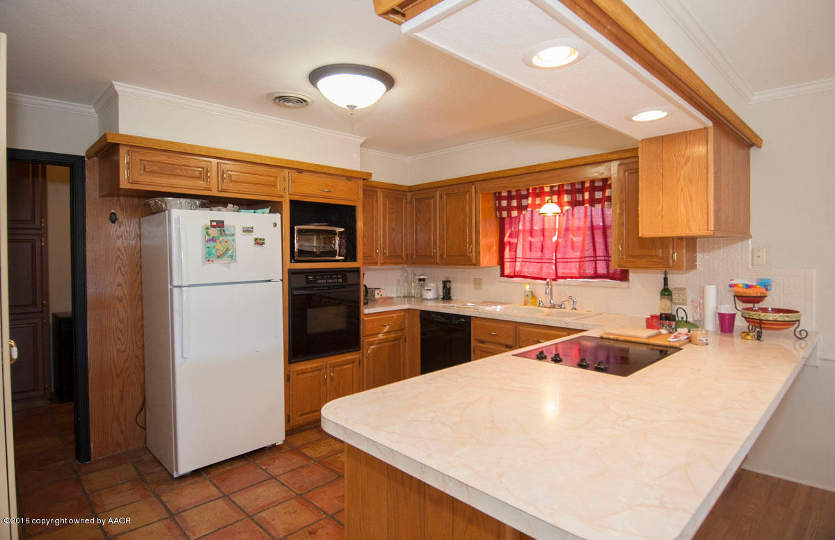 7203 Dreyfuss Road Amarillo, TX 79106 - Photo 7 of 22 a kitchen with stainless steel appliances a refrigerator sink and cabinets