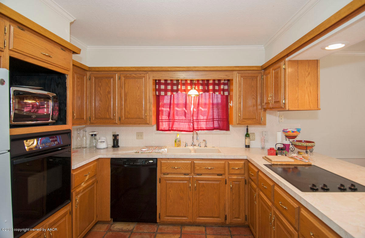 7203 Dreyfuss Road Amarillo, TX 79106 - Photo 8 of 22 a kitchen with a sink stove top oven and cabinets