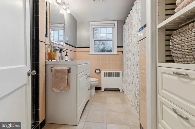 a view of washer and dryer with bathroom in the background