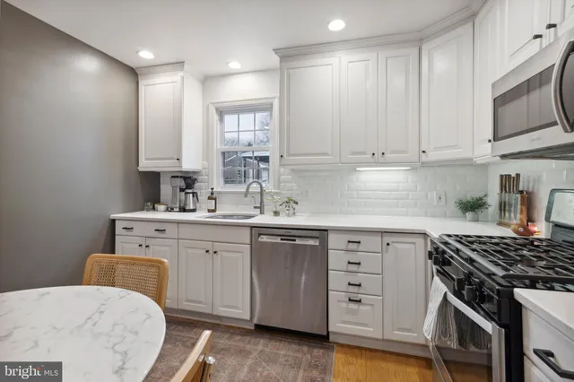 a kitchen with cabinets stainless steel appliances and a window