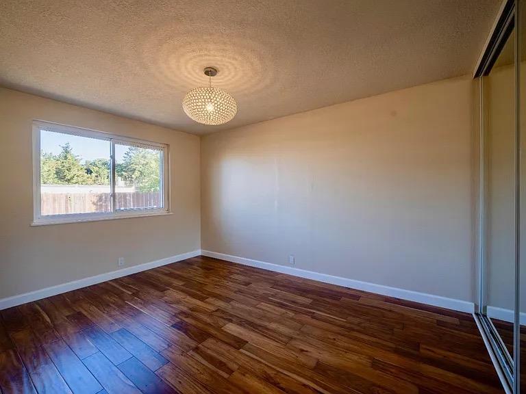 621 Forest Lake Drive Pacifica, CA 94044 - Photo 14 of 18 a view of an empty room with wooden floor and a window