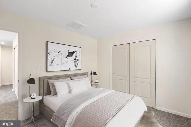 a bedroom with a bed and a painting on the wall