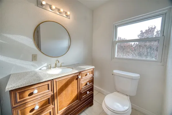 a bathroom with a toilet a sink and a window