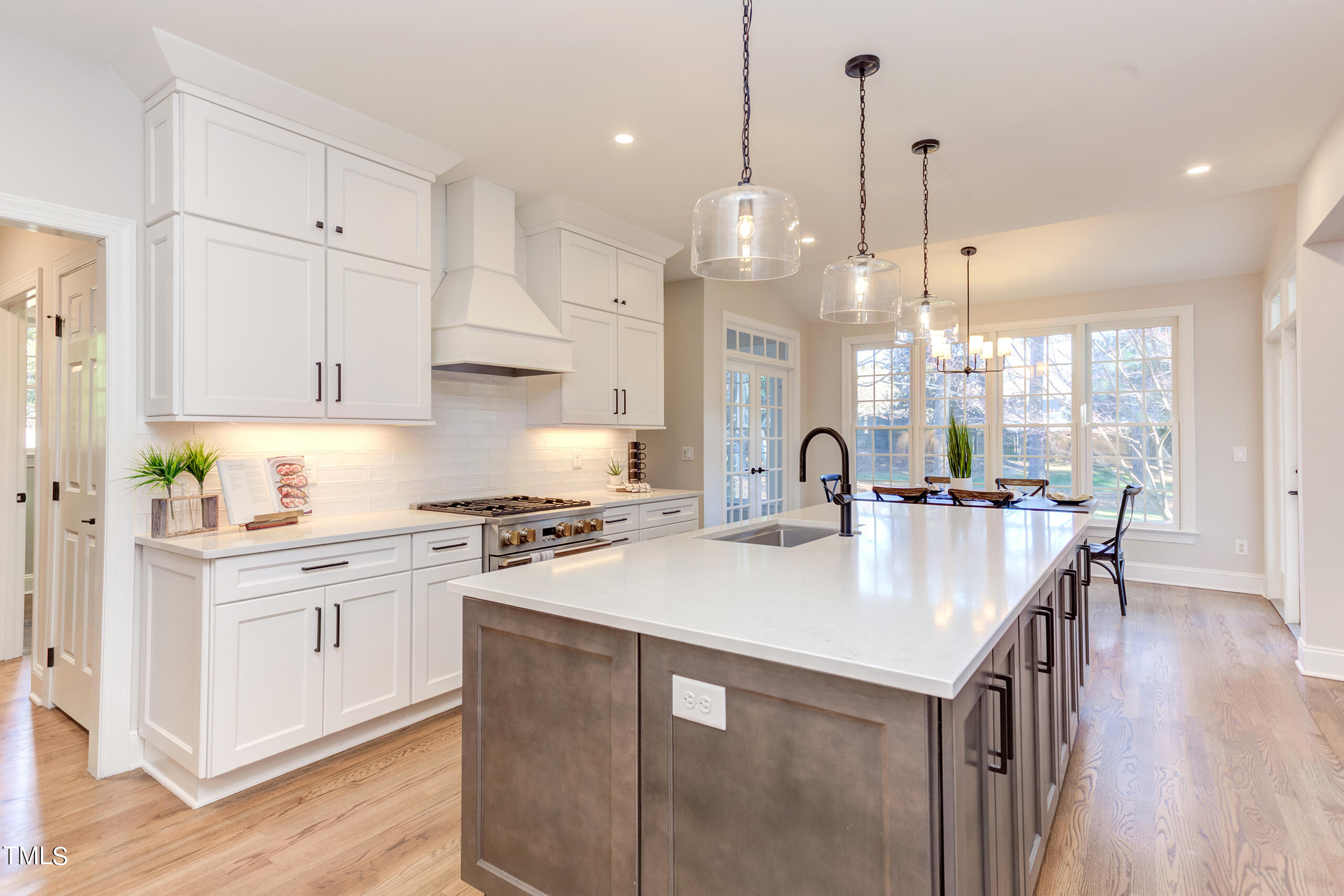737 Loch Highlands Drive Raleigh, NC 27606 - Photo 19 of 85 a kitchen with kitchen island a stove a sink a center island and wooden floor