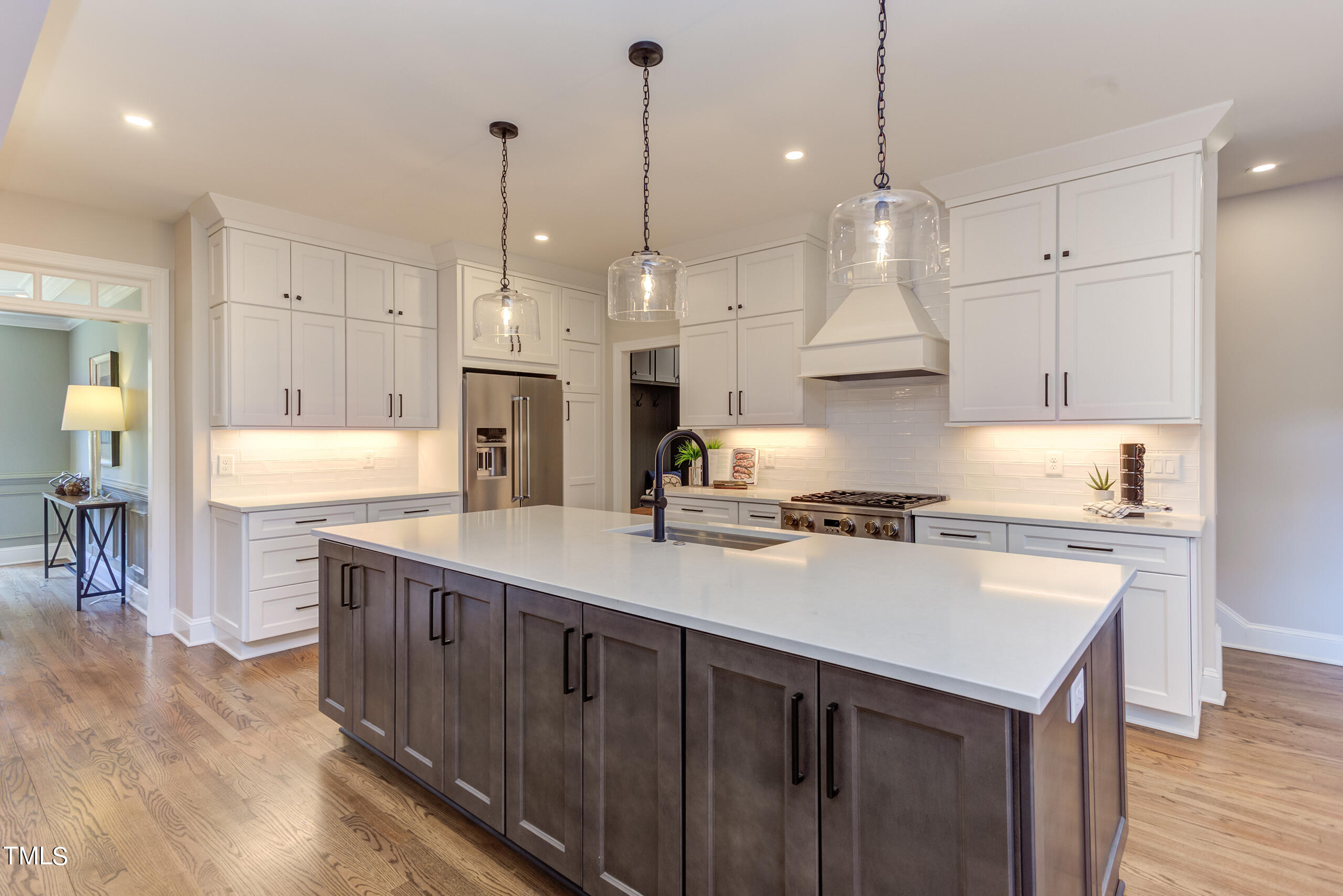 737 Loch Highlands Drive Raleigh, NC 27606 - Photo 21 of 85 a kitchen with kitchen island a stove a sink a center island and wooden floor