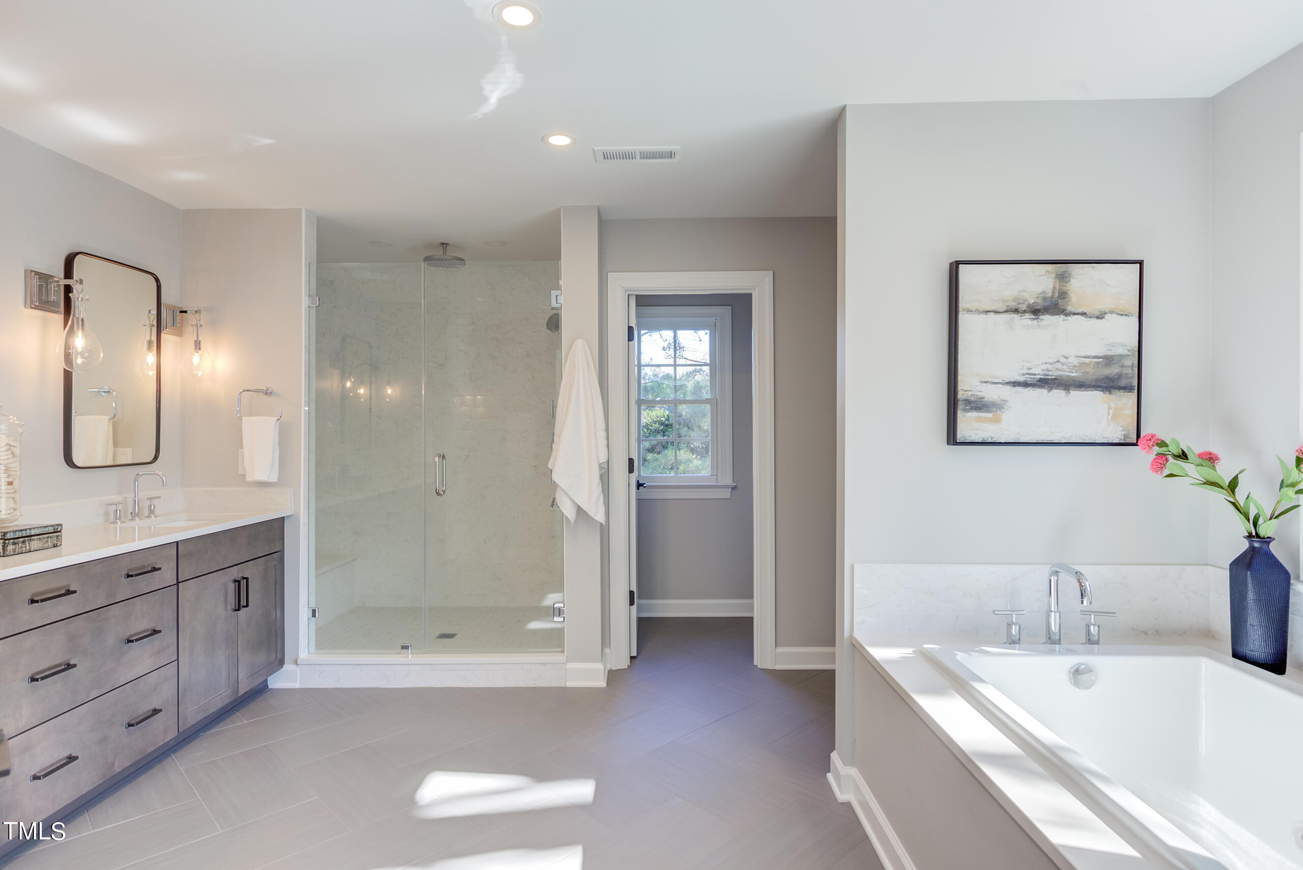 737 Loch Highlands Drive Raleigh, NC 27606 - Photo 43 of 85 a bathroom with a tub a sink and mirror