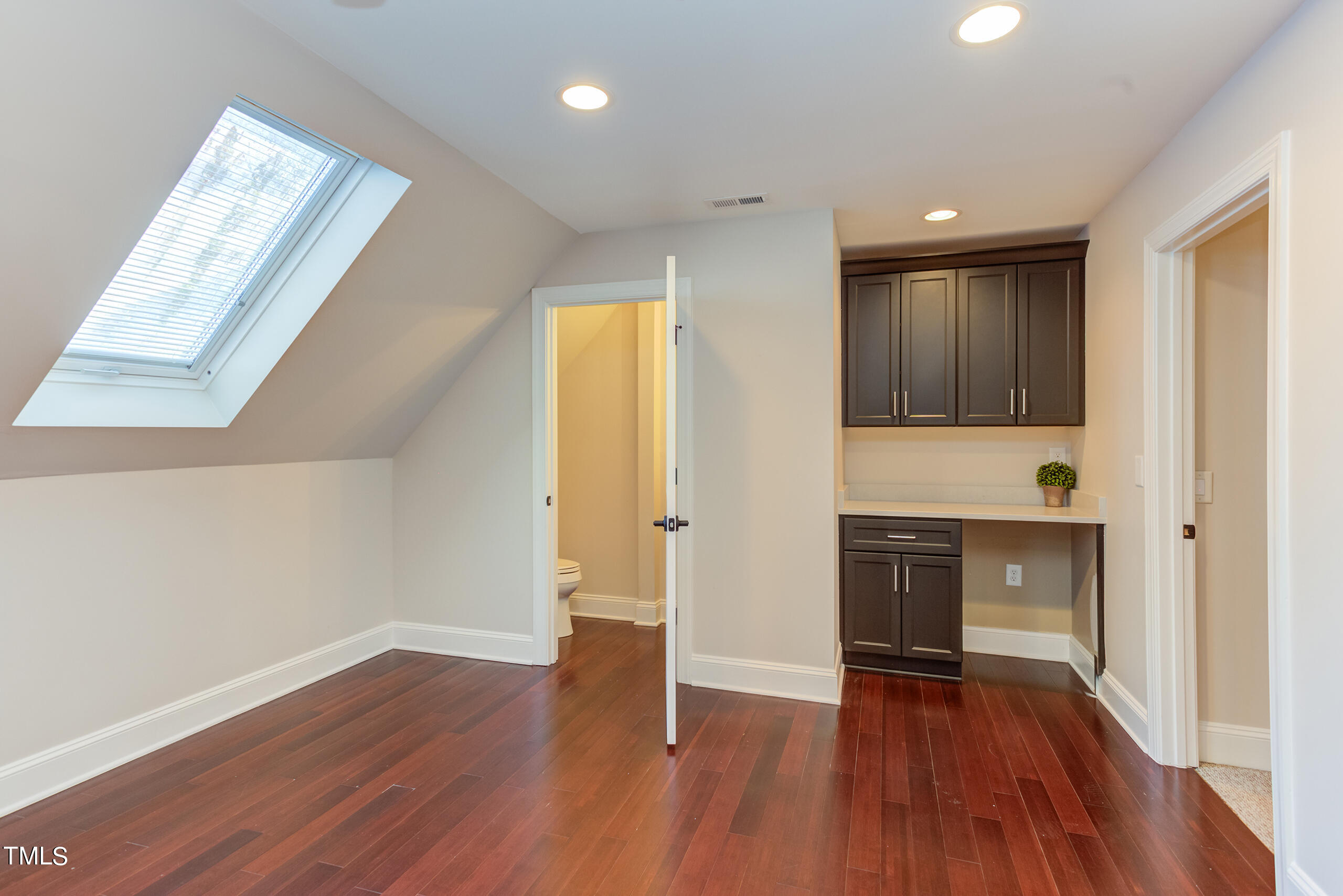 737 Loch Highlands Drive Raleigh, NC 27606 - Photo 61 of 85 a view of an empty room with window and wooden floor