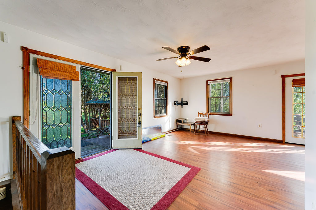 100 Nichols Ridge Road Seaman, OH 45679 - Photo 13 of 43 Bright, spacious living area with warm wood flooring and inviting outdoor access.