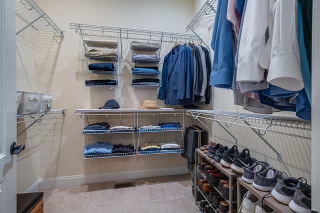 a view of walk in closet with clothes and shoes