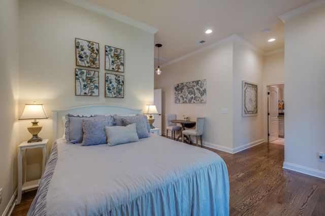 a bedroom with a large bed and a chandelier