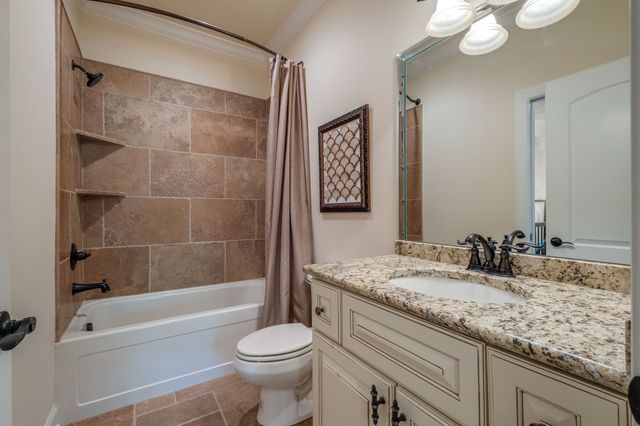 a bathroom with a granite countertop sink a toilet and bathtub